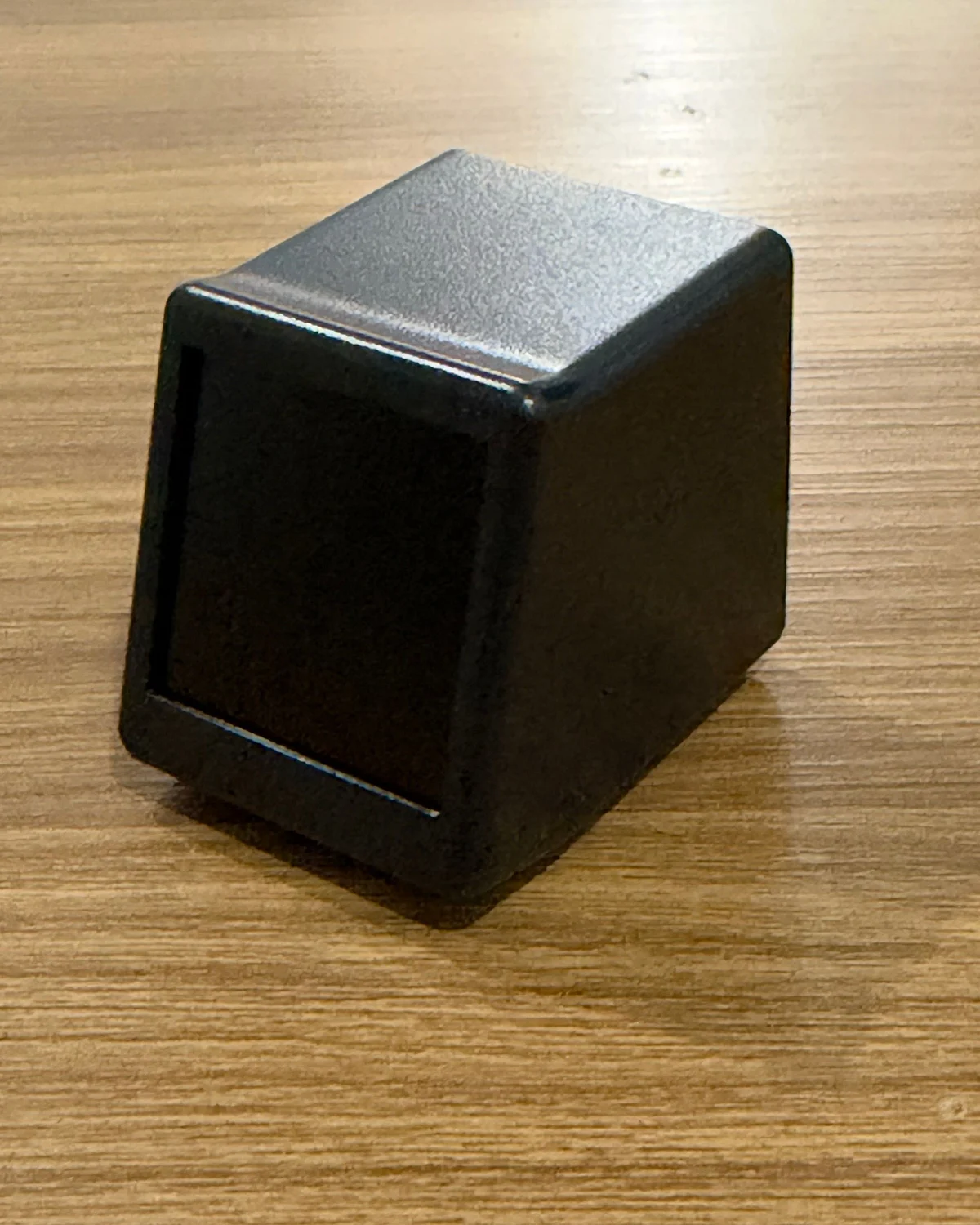 Preto em três quartos: tela, topo e lateral.